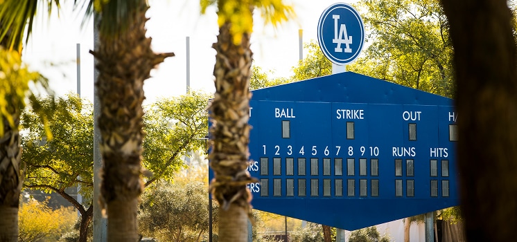 Baseball scoreboard with Los Angeles Dodgers logo in outdoor setting.