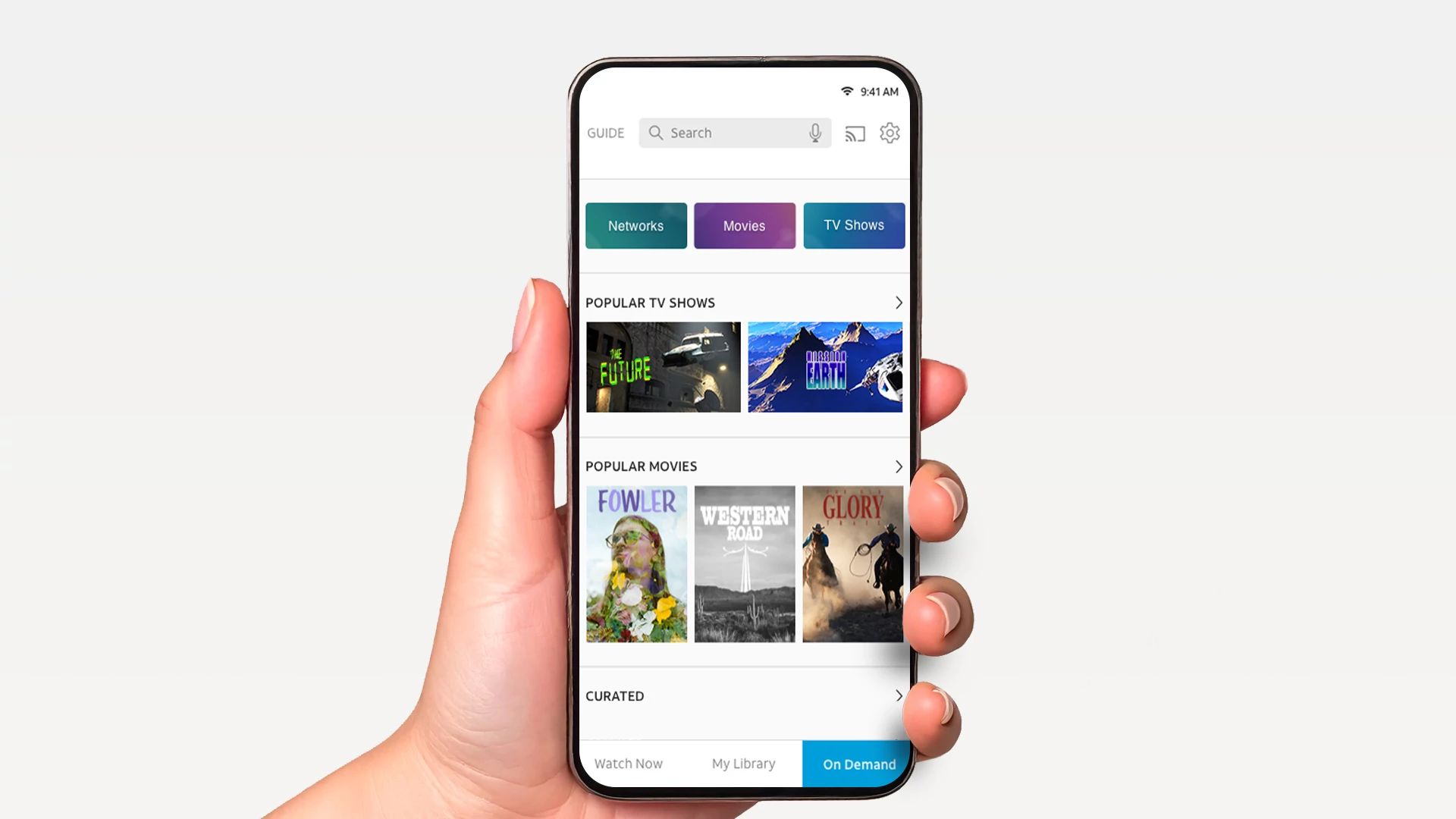 Hand holding smartphone displaying the DIRECTV app with on-demand TV shows and movies.
